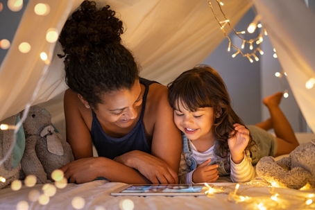 Mother and daughter smiling in tent.