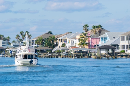 a yacht in the water in front of beachside houses