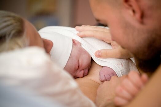 newborn child with mother and father